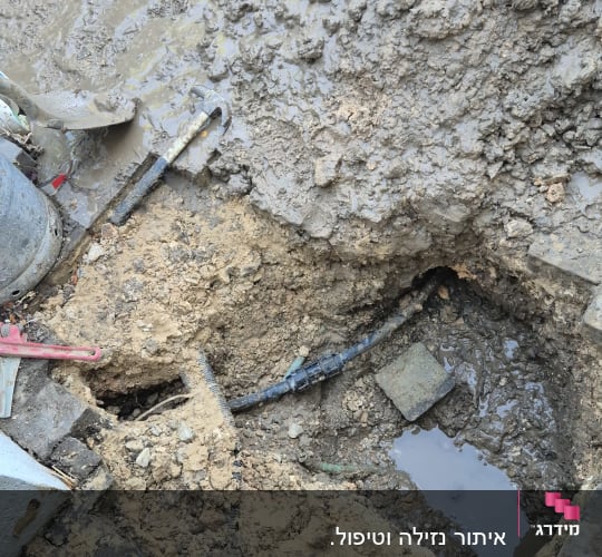 חפירה באדמה עם צינור חשוף ומים